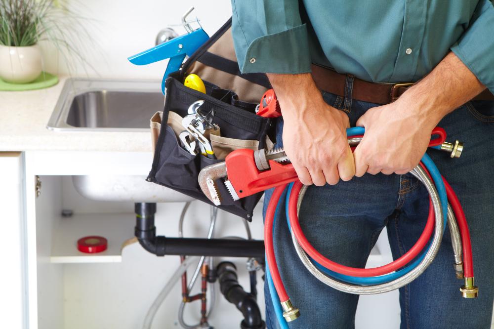 Plombier tenant des outils et des tuyaux